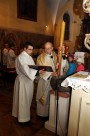 Liturgia chrzcielna celebrowana przy gotyckiej chrzcielnicy