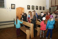 Dzieci przygotowujące się do I Komunii św. roznoszą światło